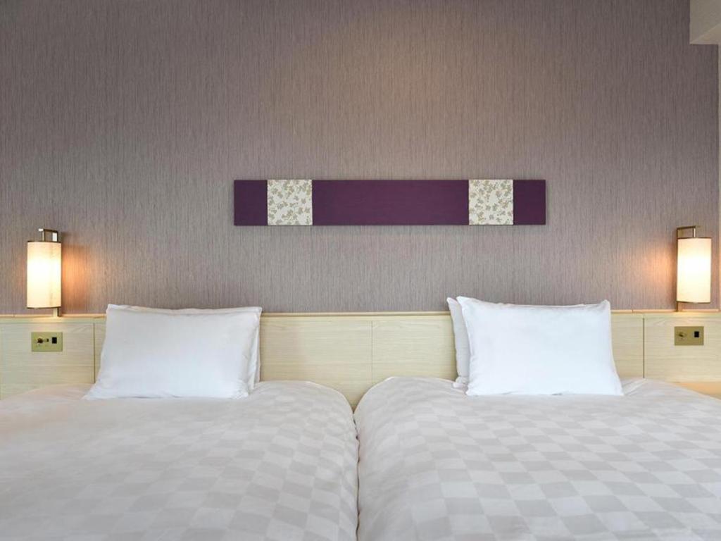 two beds sitting next to each other in a room at Shinjuku Prince Hotel in Tokyo