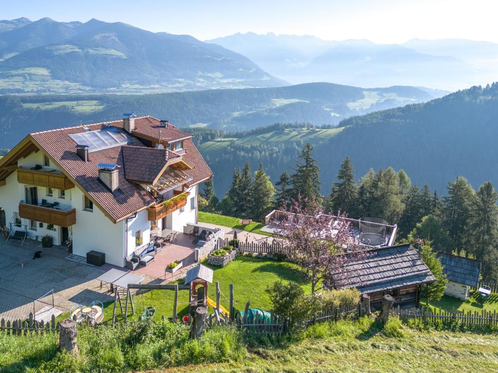une maison sur une colline avec vue sur les montagnes dans l'établissement Pirchnerhof, à San Lorenzo di Sebato