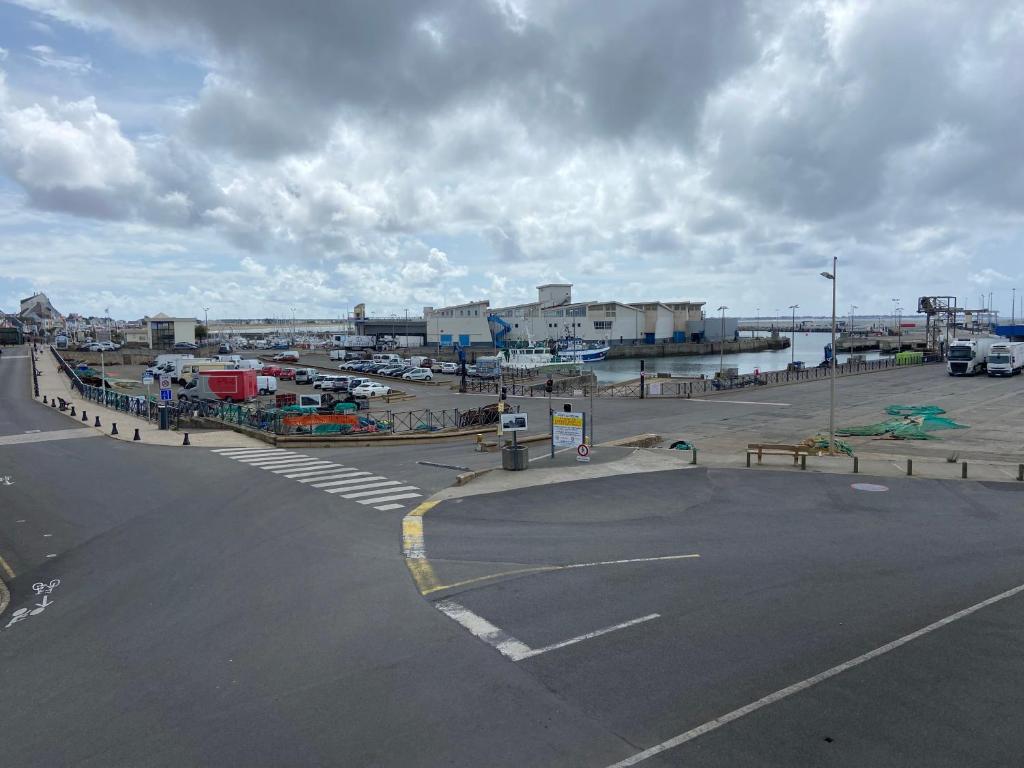 un parking vide à côté d'une masse d'eau dans l'établissement Appartement idéalement placé sur le port, à La Turballe