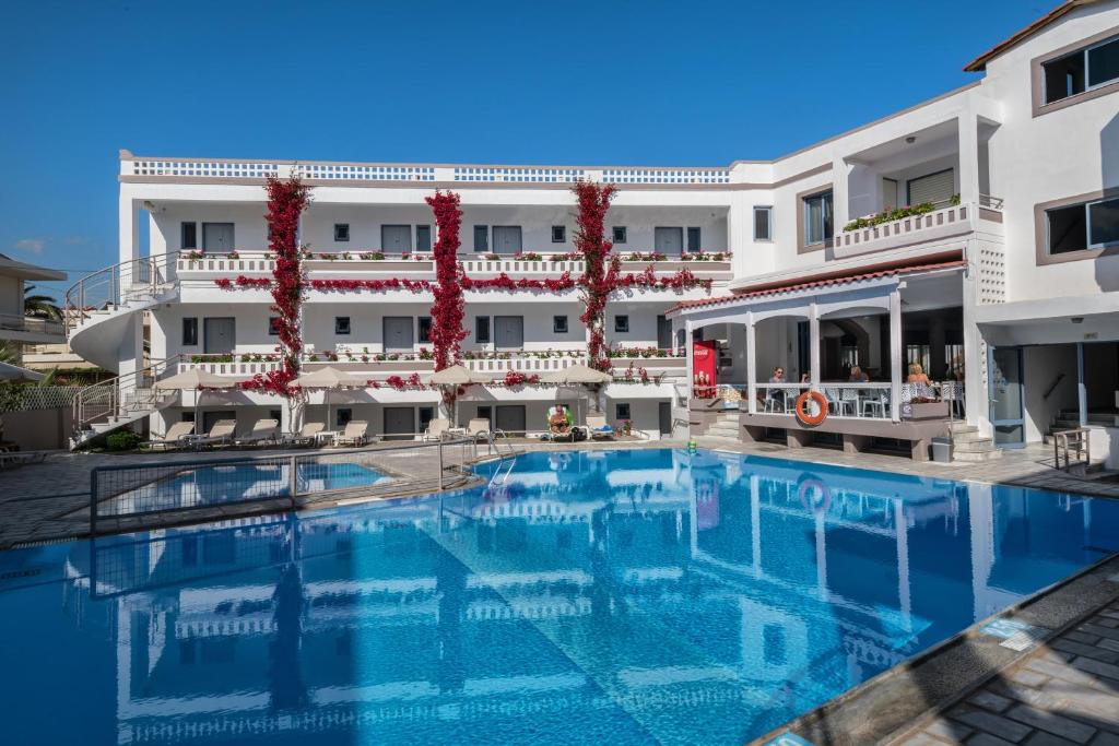 a large swimming pool in front of a building at Ariadne Hotel in Platanes