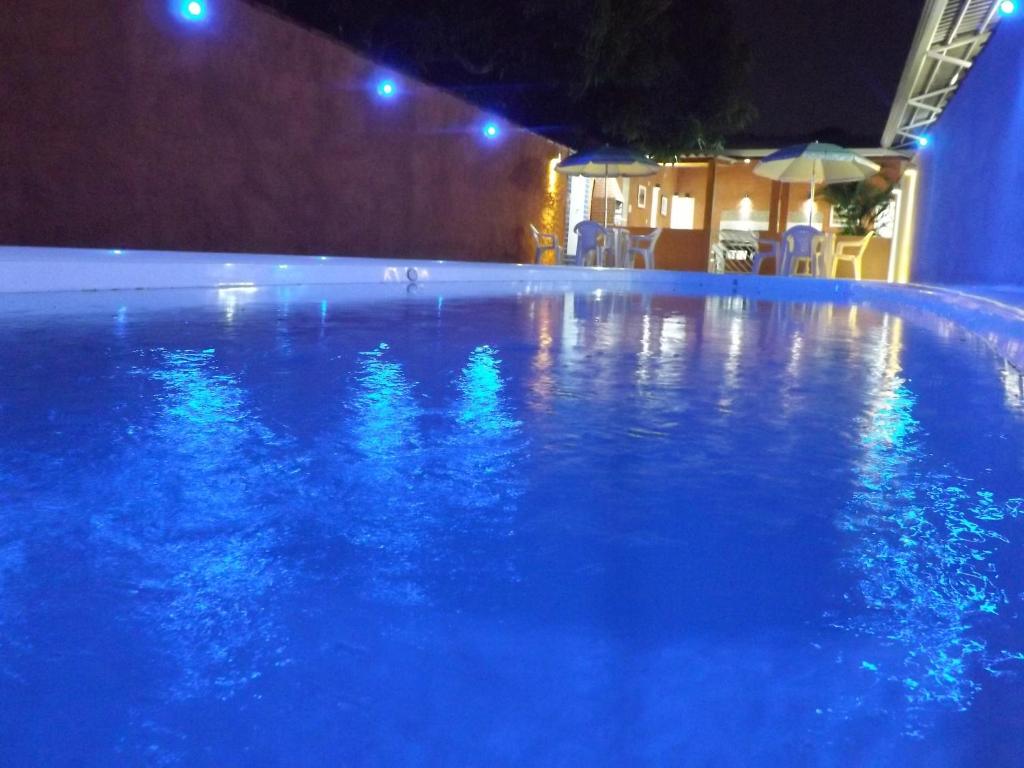 una piscina por la noche con luces azules en Hotel Buriti Itupeva, en Itupeva