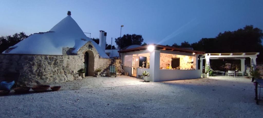 een klein huis met een verlichte tuin 's nachts bij Trullo Donna Caterina in Ceglie Messapica