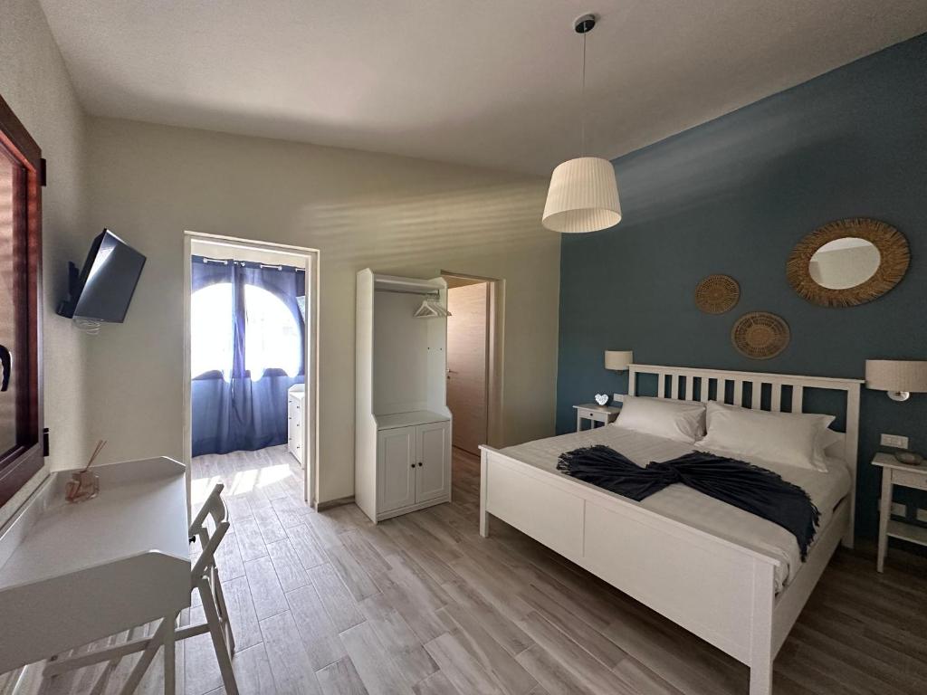 a bedroom with a bed and a desk and a mirror at Villa Blue Paradise Relax con piscina a pochi minuti da Cagliari e dal mare in Cagliari