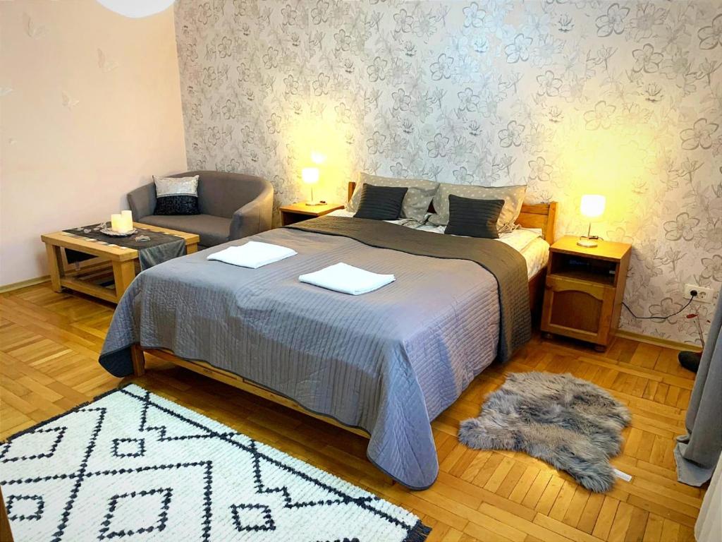 Ghimbav的住宿－Andreea Residence，一间卧室配有一张床、一张沙发和一把椅子