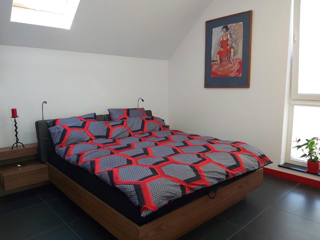łóżko z czerwoną i czarną kołdrą w pokoju w obiekcie Apartament Parkowa 2 w Morągu