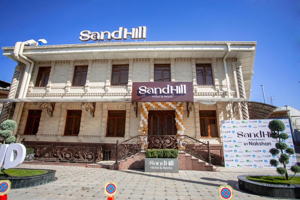 a building with a sign on the front of it at SandHill Hotel Samarkand in Samarkand