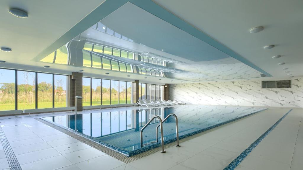 a large swimming pool in a building with windows at Prywatne apartamenty Sun & Snow w Porta Mare Marina z basenem in Dziwnów