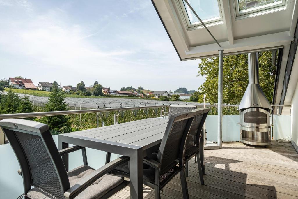 einen Holztisch und Stühle auf einem Balkon mit Flussblick in der Unterkunft Ferienwohnung Zur Imme in Lindau
