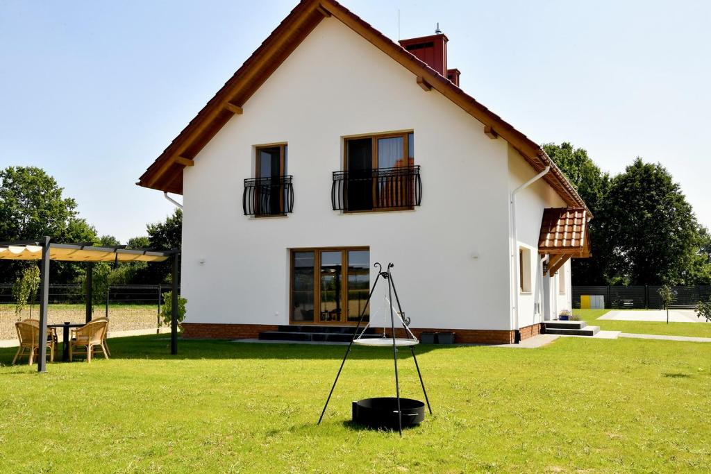 a house with a tripod in the grass at Dobranocka Noclegi - blisko Energylandia in Spytkowice
