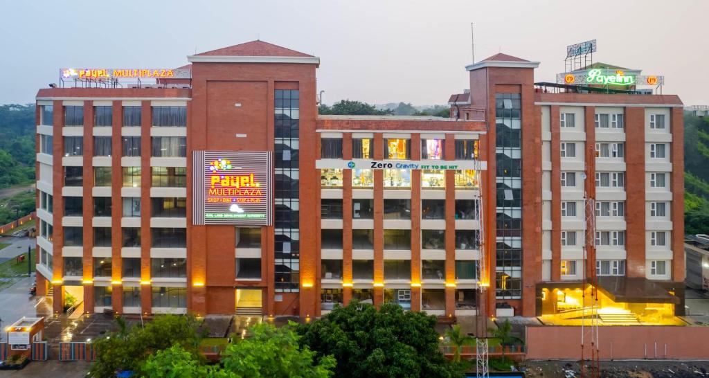 two large brick buildings in a city at night at Payel Inn in Āsansol