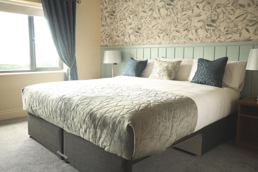 a bedroom with a large bed with a large window at The Coachmans Inn in Roscommon