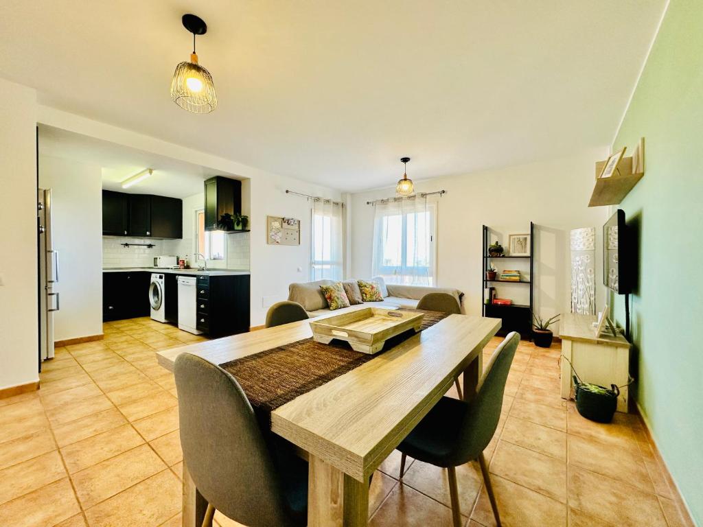 a kitchen and living room with a wooden table and chairs at Casa Adele terraza del mar in Corralejo