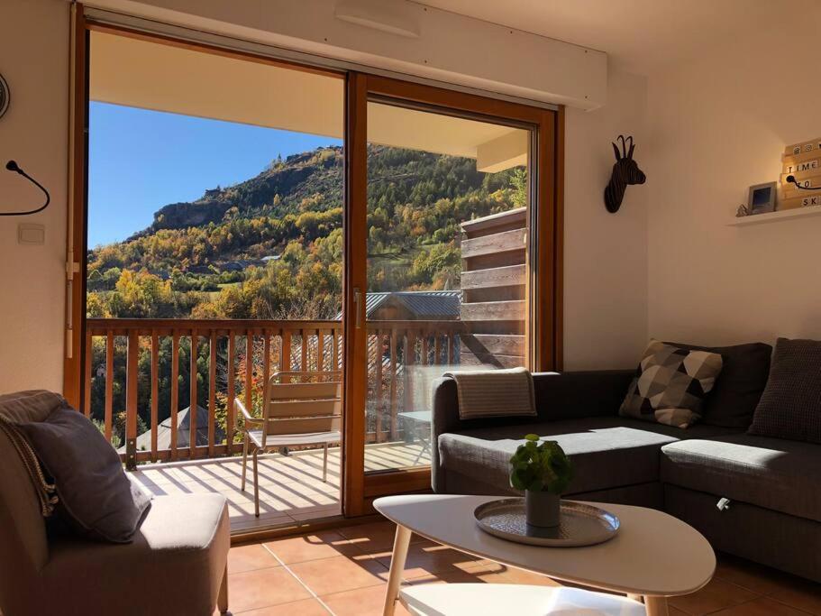 ein Wohnzimmer mit einem Sofa und einem großen Fenster in der Unterkunft Nice Appt In Briançon Les Charmettes in Briançon