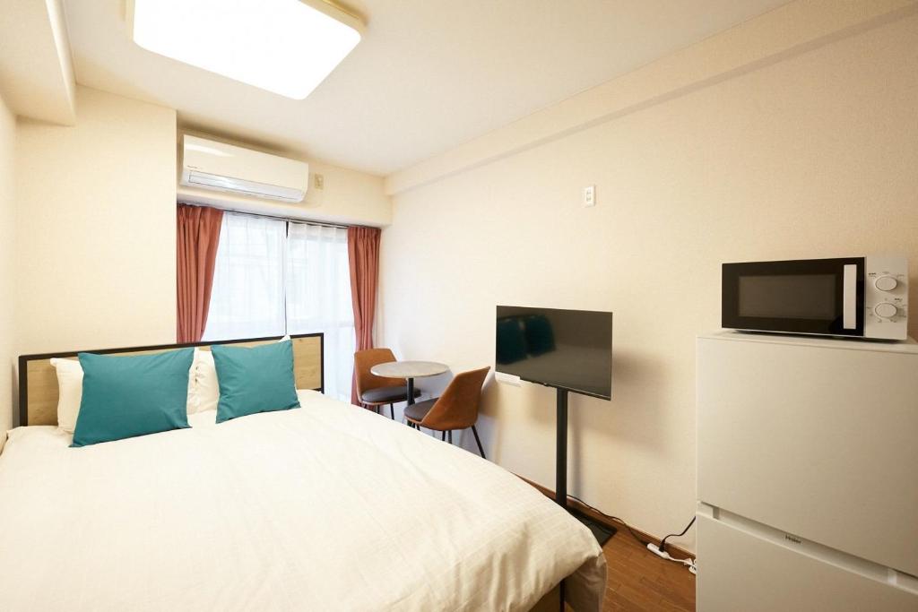 a hotel room with a bed and a flat screen tv at Garden Otsuka in Tokyo