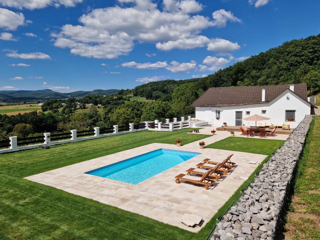 een achtertuin met een zwembad en een huis bij Villa Lindenberg Slovakia in Krupina