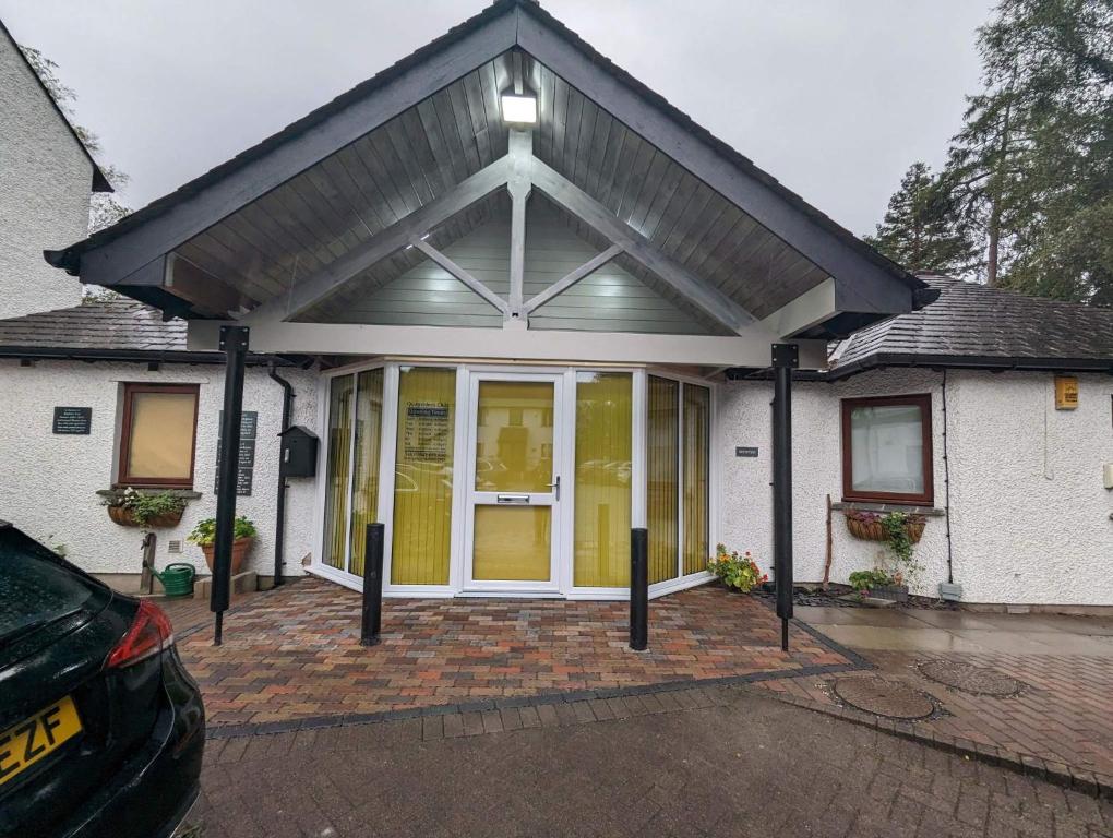 a detached house with a garage with a pitched roof at Quaysiders Club in Ambleside