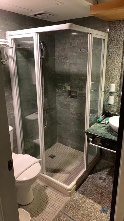 a bathroom with a shower with a toilet and a sink at CHECK inn Express Taichung Fengchia in Taichung