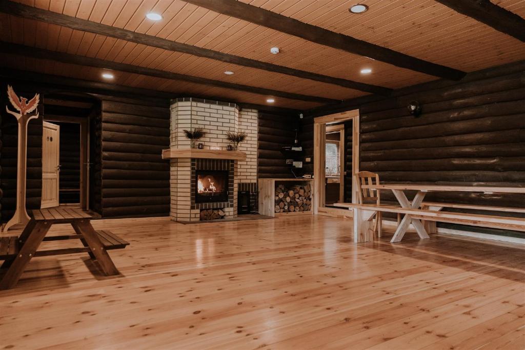 a living room with a fireplace and wooden walls at Holiday home Migliņas in Kaugurmuiza