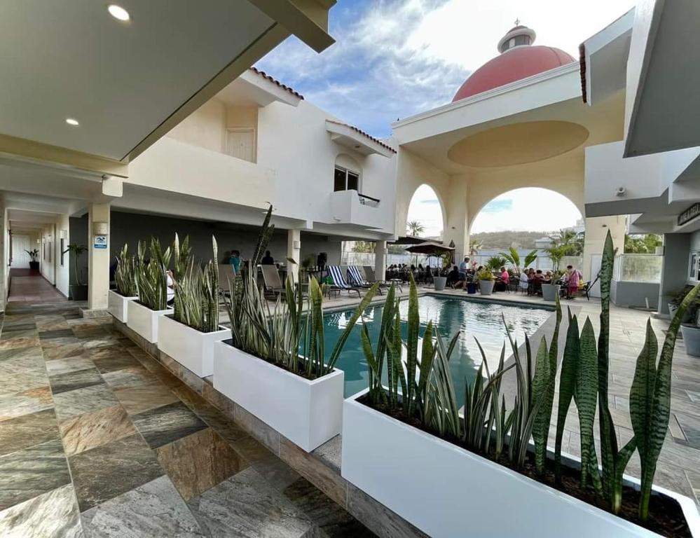a hotel with a swimming pool and plants in the courtyard at Suites Las Palmas in San José del Cabo