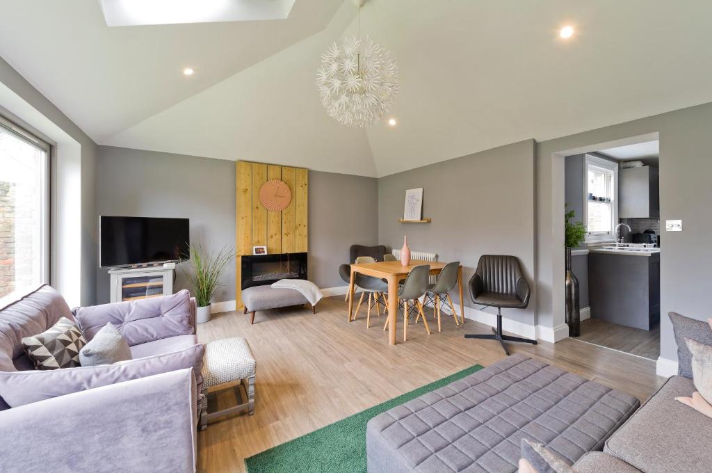 ein Wohnzimmer mit einem Sofa und einem Tisch in der Unterkunft Stylish Family Home by Twickenham Stadium by UnderTheDoormat in London