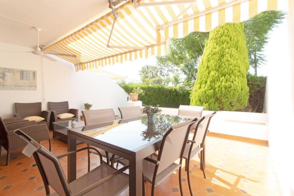 uma sala de jantar com mesa e cadeiras em Global Properties, Adosado con piscina en la playa de Canet em Canet d'En Berenguer