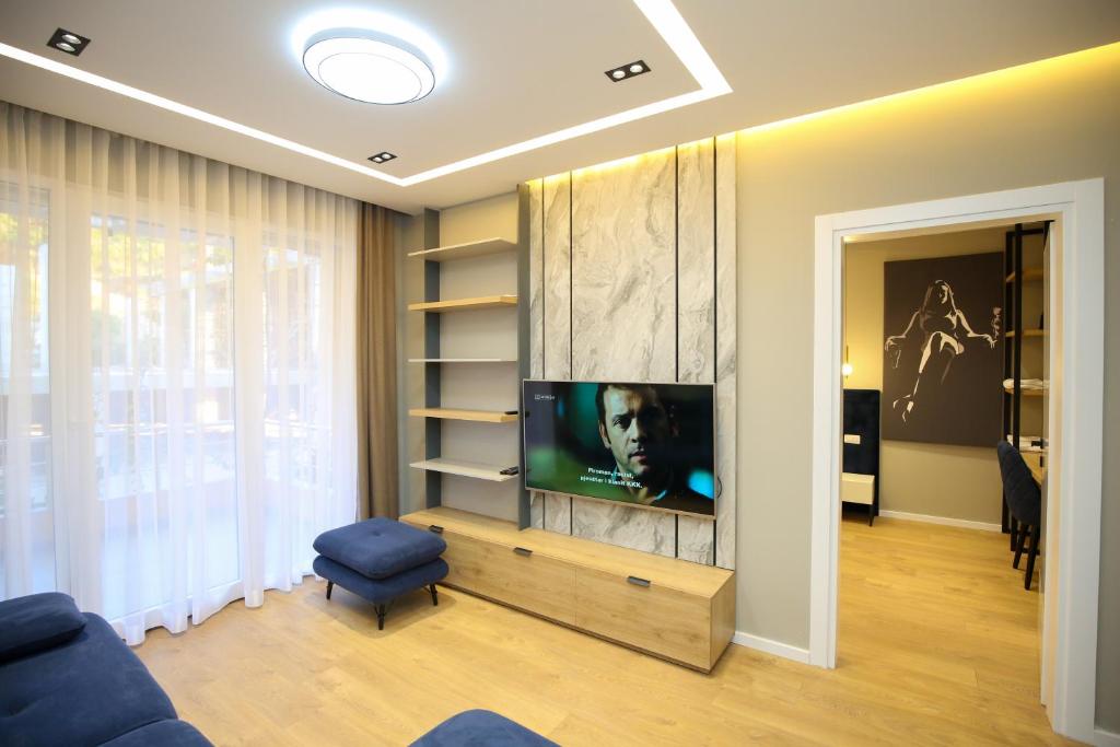 a living room with a flat screen tv on a wall at LA LA Marina Wave Suites in Vlorë