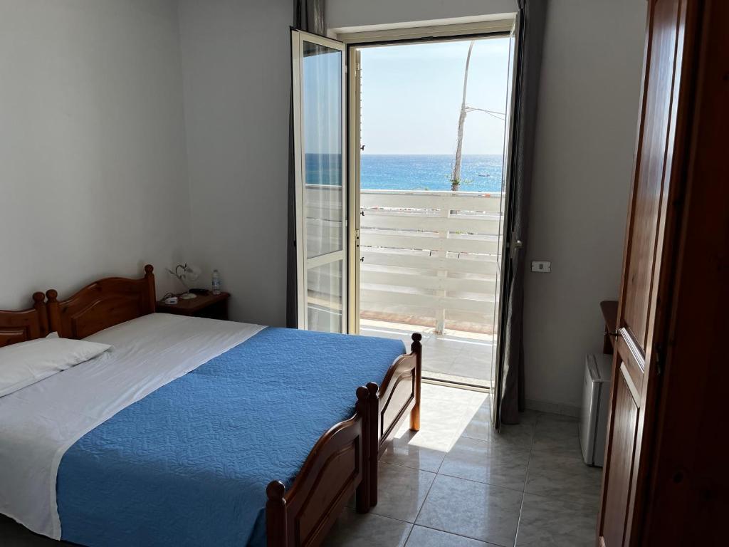 um quarto com uma cama e vista para o oceano em Petit gourmet em Siderno Marina