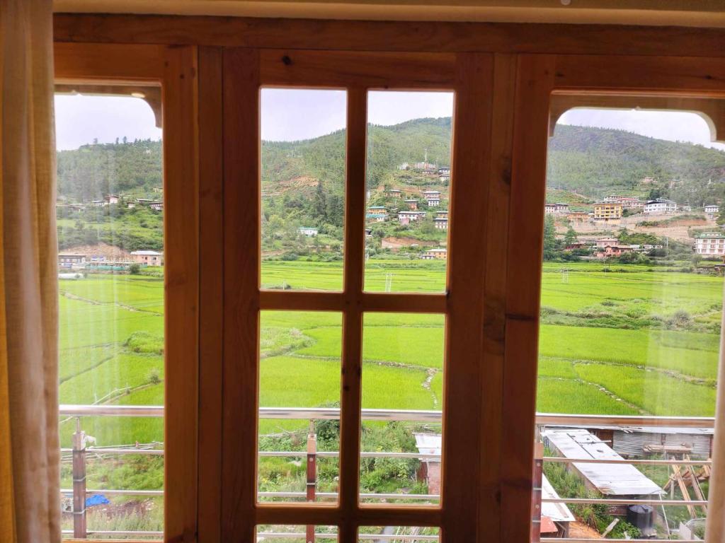 a window with a view of a green field at Green valley boutique in Paro