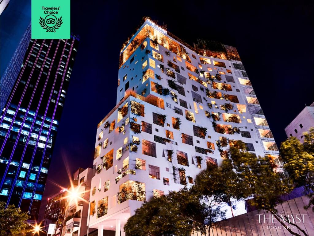 a tall white building with windows at night at The Myst Dong Khoi in Ho Chi Minh City