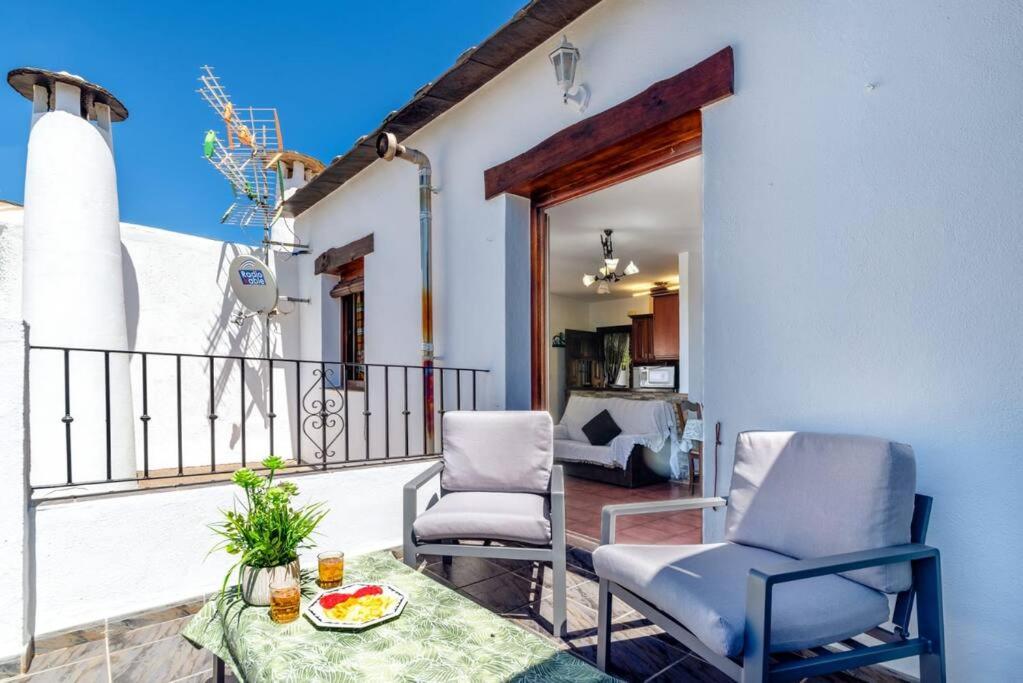 a patio with two chairs and a table on a balcony at Casa Jose Capileira - Alpujarra in Capileira