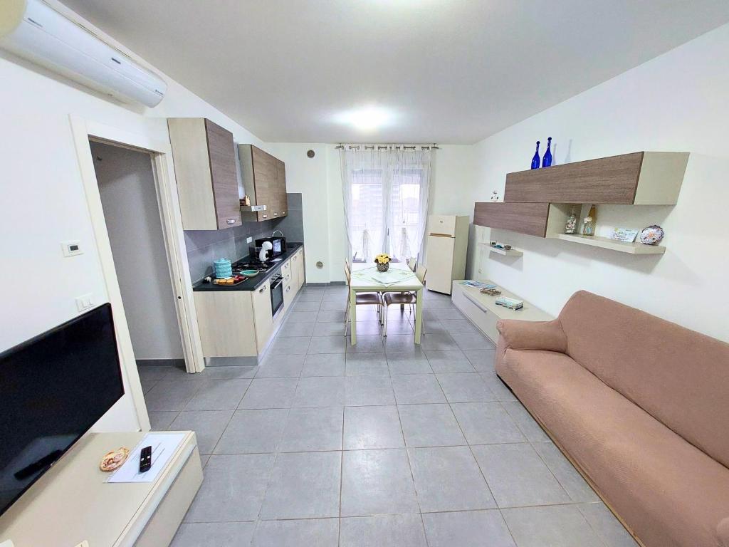 eine Küche und ein Wohnzimmer mit einem Sofa und einem Tisch in der Unterkunft Appartamento Palazzo Moretto in Chioggia