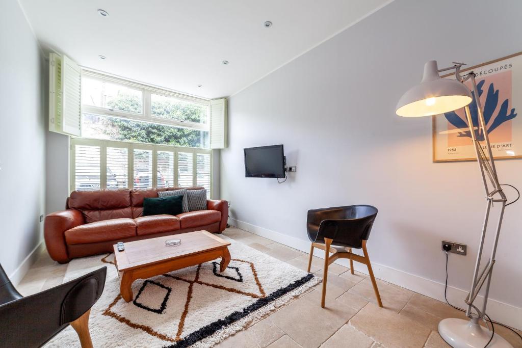 a living room with a couch and a table at Bright Groundfloor 3BR Flat, Brockley, SE London in London