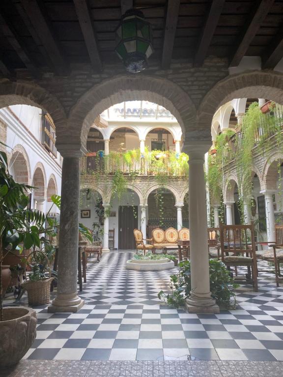 een binnenplaats met tafels en stoelen in een gebouw bij Hostal Palacio del Corregidor in Córdoba