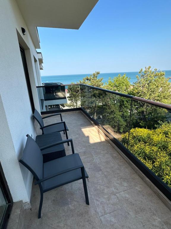 balkon z krzesłami i widokiem na ocean w obiekcie FORREST Villa w mieście Eforie Nord