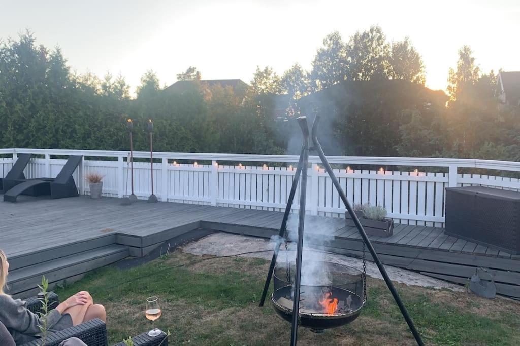 een vuurplaats in een tuin met een grill bij Trivelig villa med innendørs peis in Fredrikstad