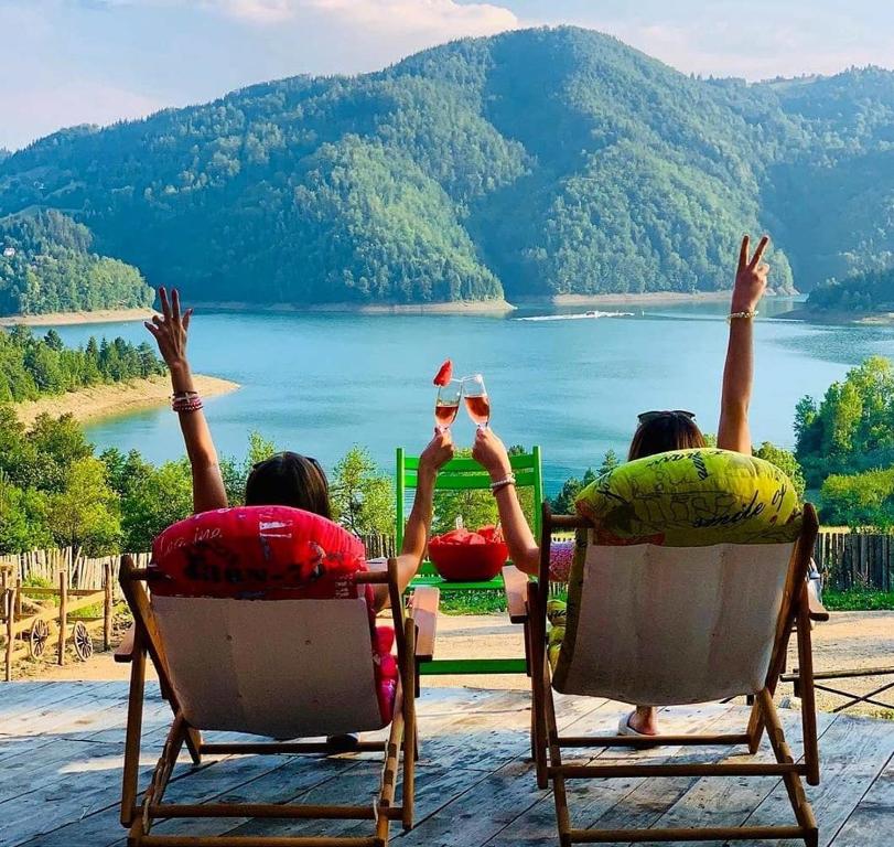 dos personas sentadas en sillas con las manos en el aire en Tara Land Lake en Zaovine