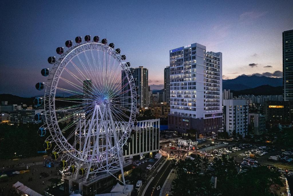 una grande ruota panoramica in una città di notte di Urbanstay Sokcho beach C a Sokcho