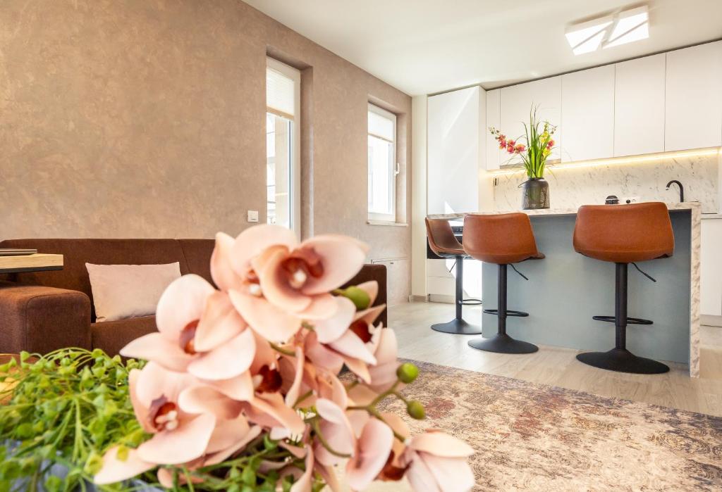 a living room with a couch and a table with flowers at 5th Floor Executive Apartment with Balcony and Free Parking in Braşov