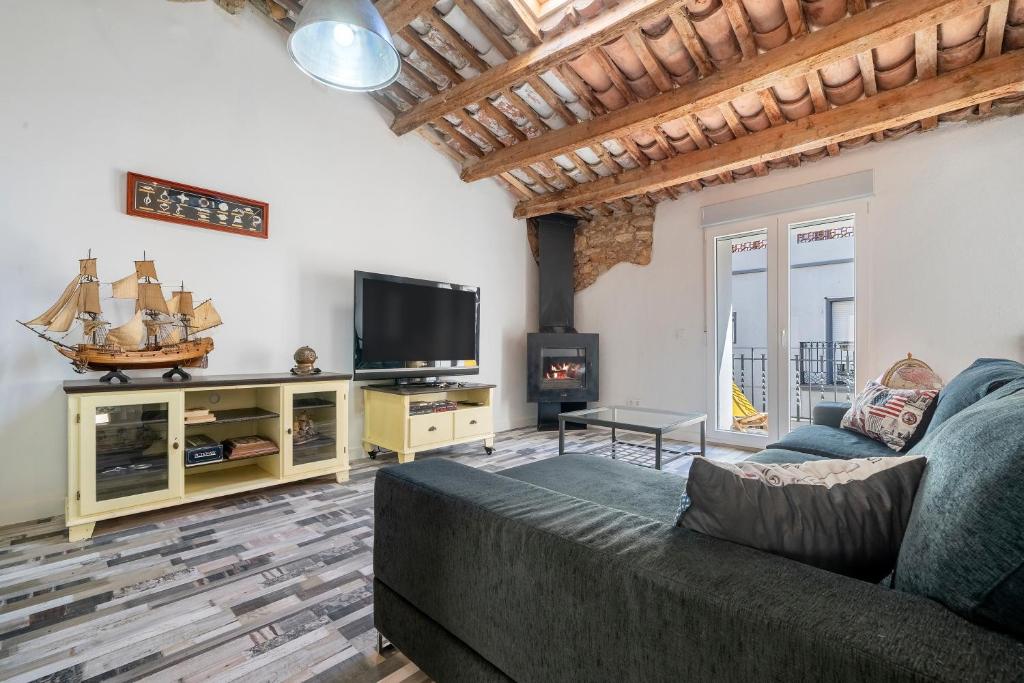 ein Wohnzimmer mit einem Sofa und einem Flachbild-TV in der Unterkunft Ca la Rápita in Sant Carles de la Ràpita
