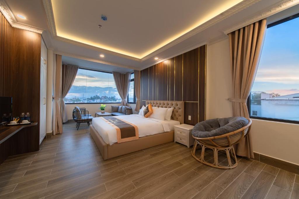 ein Hotelzimmer mit einem Bett, einem Stuhl und einem Fenster in der Unterkunft BẢO DUY HOTEL 5 in Da Lat