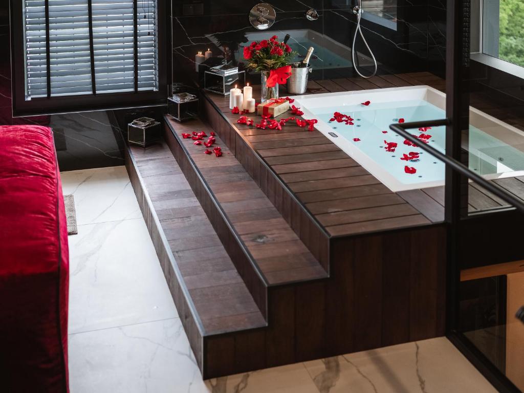 a bathtub with candles and flowers in a bathroom at Art Penthouse with Jacuzzi - Krakow Center in Krakow