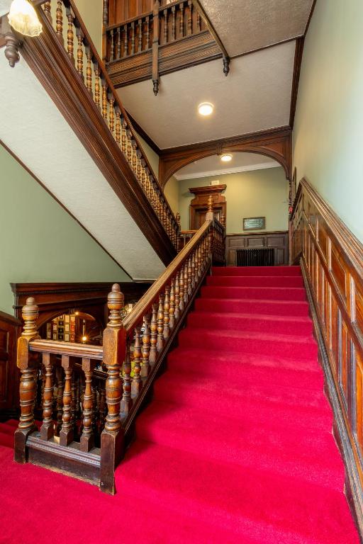 a staircase with a red carpet in a house at Palmers Lodge Swiss Cottage in London