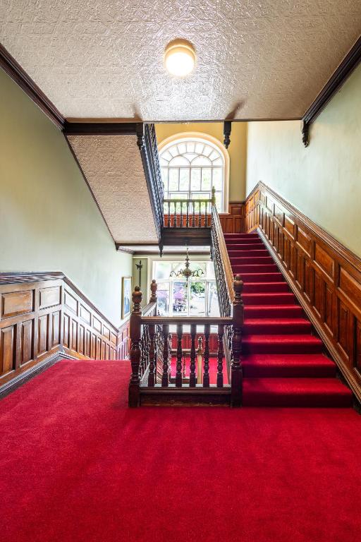a staircase in a church with a red carpet at Palmers Lodge Swiss Cottage in London