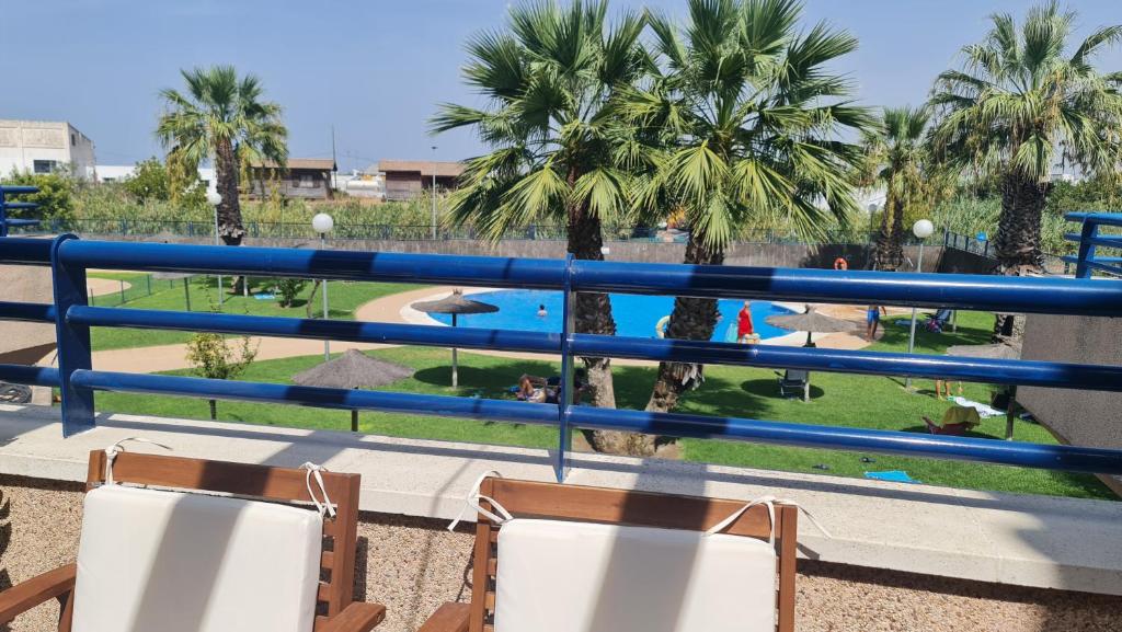 a balcony with chairs and a view of a pool at Aires de Doñana. Piscina y Playa. Parking gratis. in Sanlúcar de Barrameda