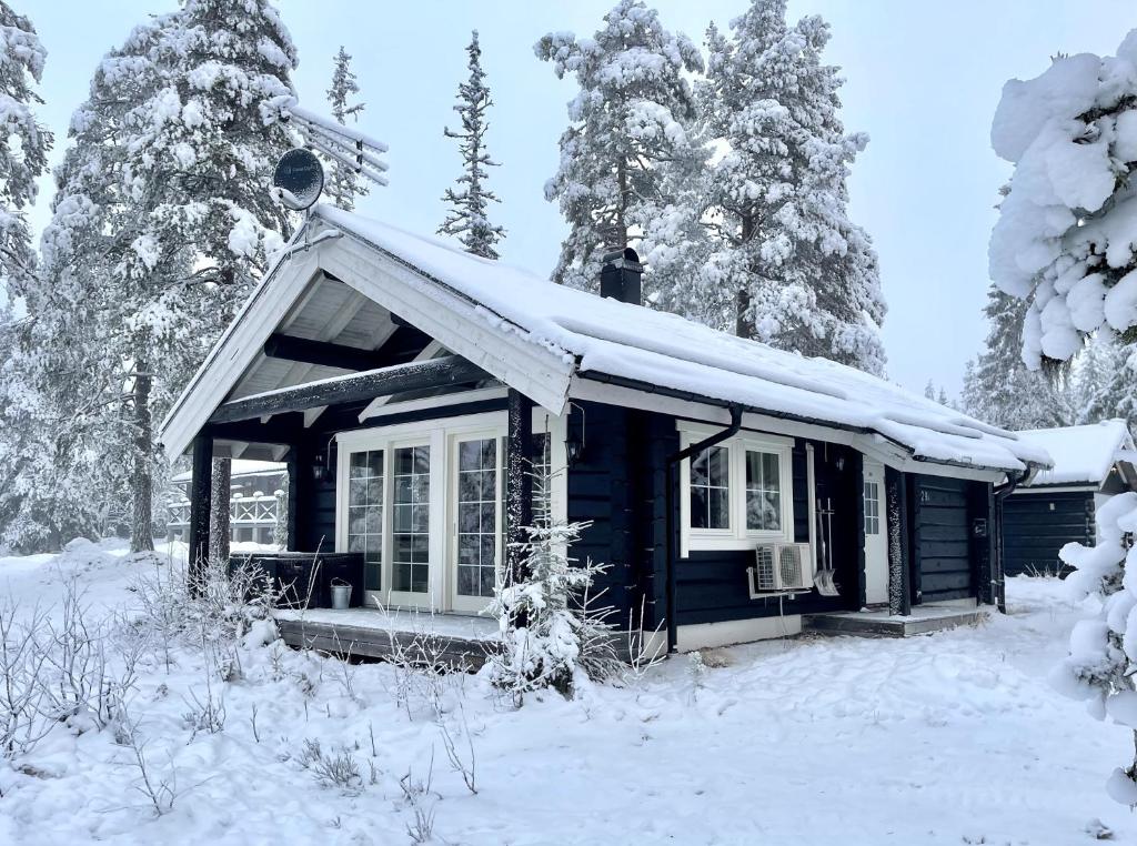 uma pequena casa azul com neve no telhado em Mysig timmerstuga med utsikt över Tandådalens anläggningar em Sälen