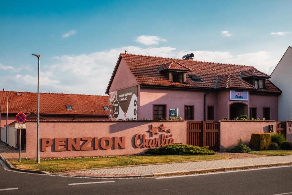 a building with a sign on the side of a wall at Penzion Charlie in Mohelnice