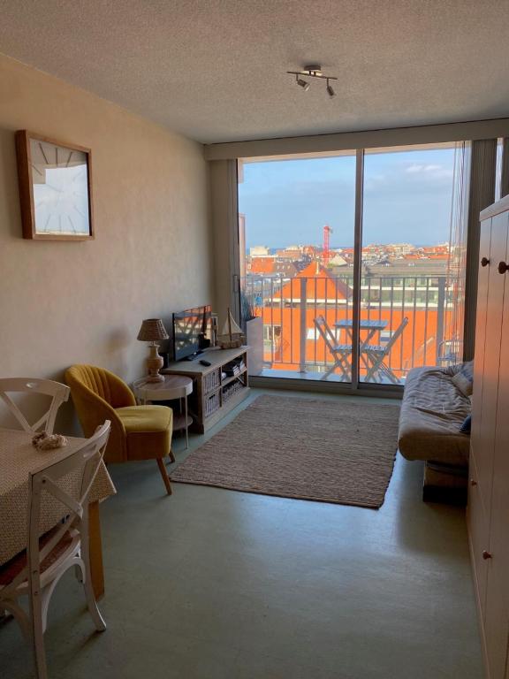 a living room with a view of a city at Au 9 sans 6 : Studio lumineux vue mer latérale in Nieuwpoort