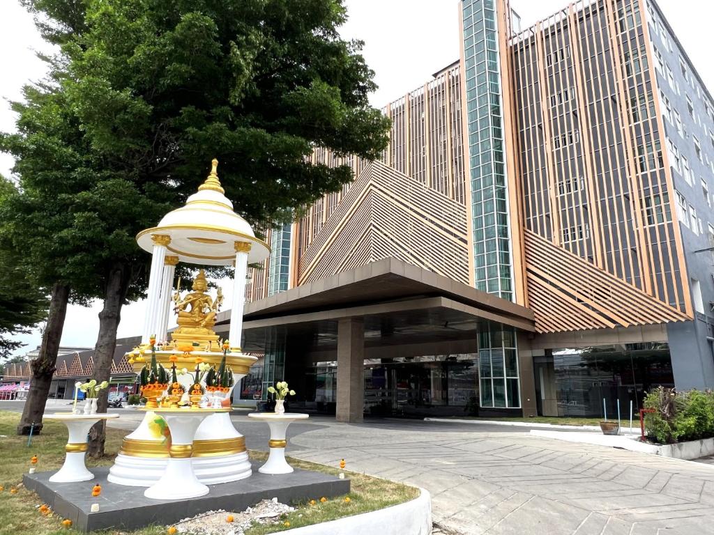 a building with a tower in front of a building at The Srivaree Airport Hotel in Samutprakarn