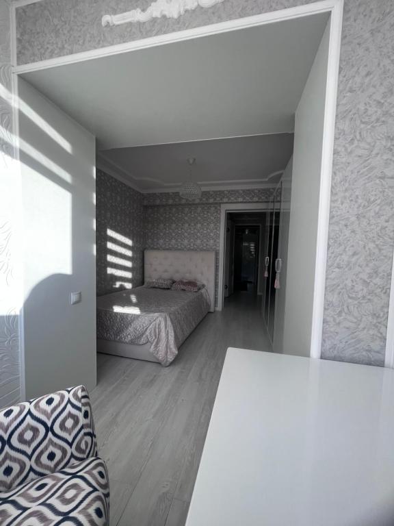 sypialnia z łóżkiem i stołem w pokoju w obiekcie Уютная 3 комнатная квартира w mieście Uralsk