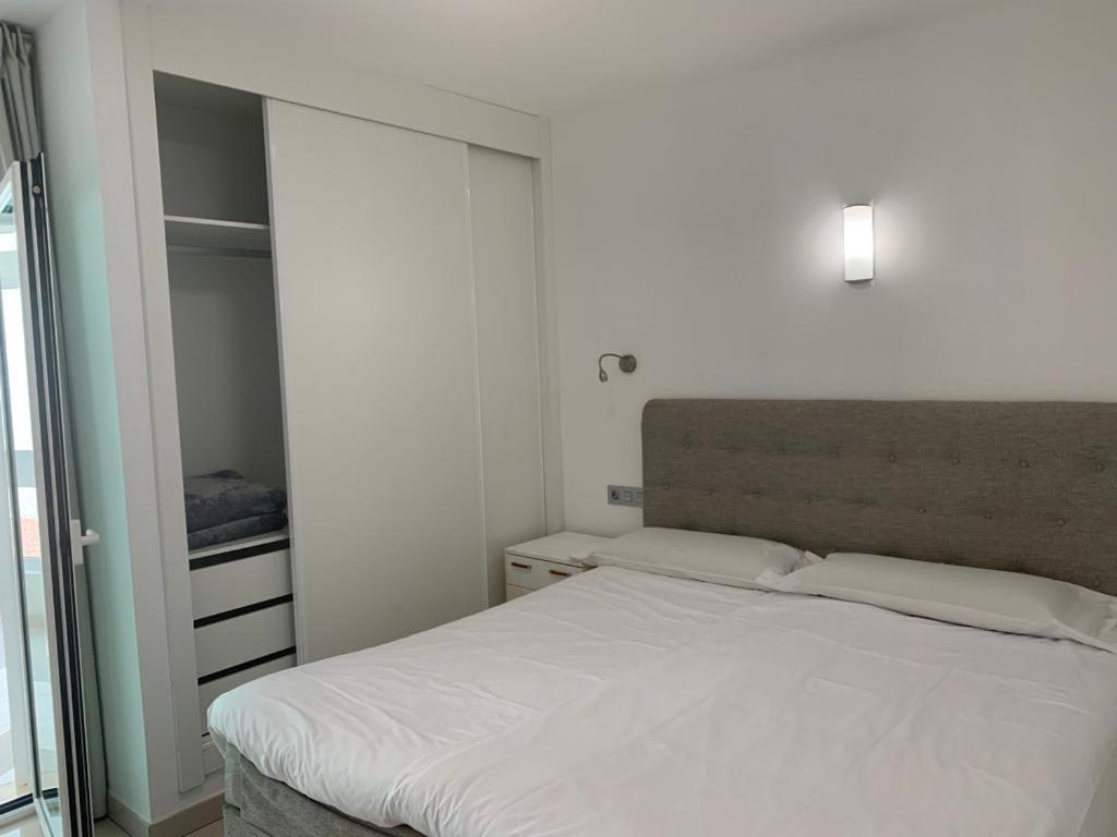 a bedroom with a white bed and a closet at CASA JAGGER in Costa Calma